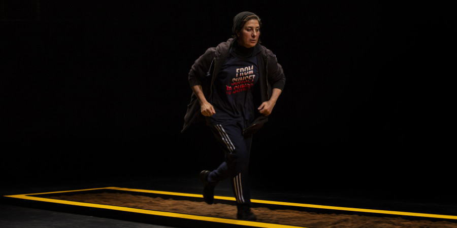 Eine Frau l&auml;uft im Hoodie in Eile &uuml;ber die B&uuml;hne, Theaterst&uuml;ck The child