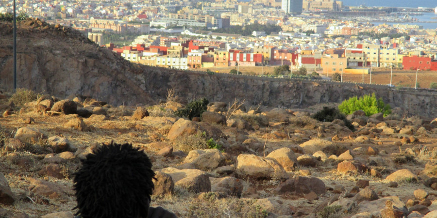 Ein Mann sitzt auf dem Berg Gurugu und blickt auf die spanische Enklave Melilla