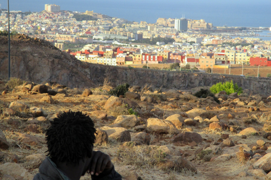 Ein Mann sitzt auf dem Berg Gurugu und blickt auf die spanische Enklave Melilla